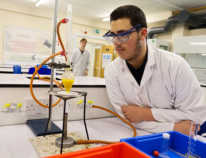 George keeps an eye on his refluxing apparatus once it’s being heated. You can clearly see the colour from the orange peel added to the water in the pear-shaped flask