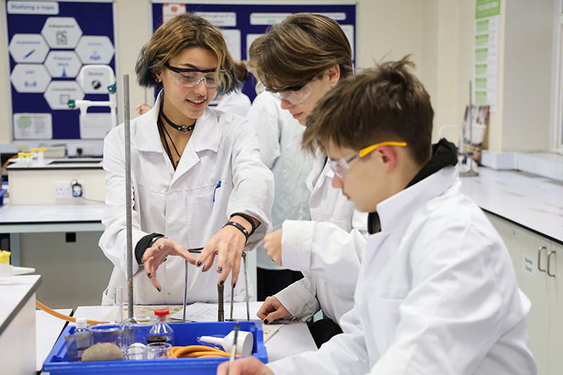 Zeynep, Sofia and Steven discuss how to set their apparatus up.